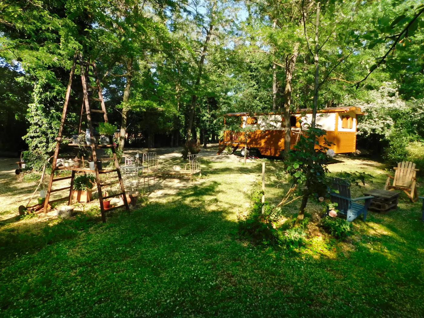 Der baumbestandene Garten, im Hintergrund die Roulotte zwischen den Bäumen